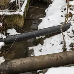 Zimowy krajobraz z rurami i strumieniem. Warto pamiętać, przy jakiej temperaturze pękają rury, by uniknąć awarii.
