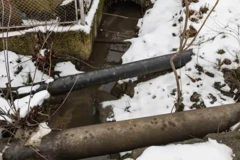 Zimowy krajobraz z rurami i strumieniem. Warto pamiętać, przy jakiej temperaturze pękają rury, by uniknąć awarii.